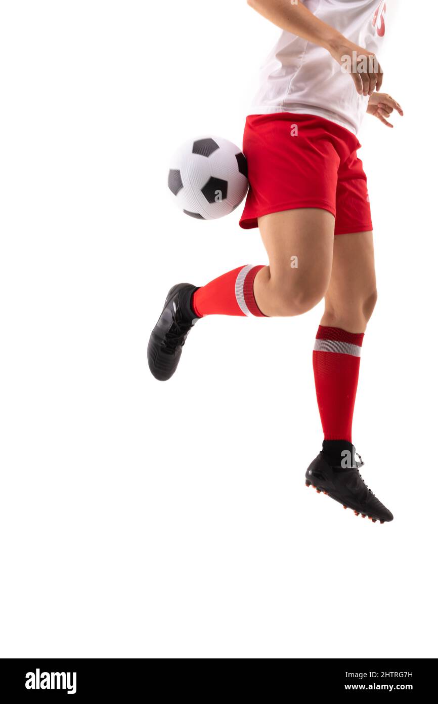 Niedriger Abschnitt der biracial junge weibliche Spieler tritt Fußball mit rücker Ferse, während Fußball zu spielen Stockfoto