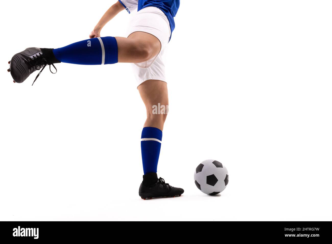 Niedriger Abschnitt der biracial weiblichen Fußballspielerin tritt Fußball vor weißem Hintergrund Stockfoto