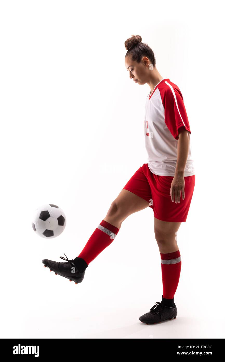 Die ganze Länge der biracial junge Fußballspielerin jongliert Fußball mit Fuß Stockfoto