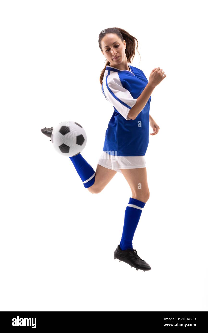 Die ganze Länge der kaukasischen jungen Spielerin tritt beim Fußballspielen den Fußball mit rücker Ferse Stockfoto