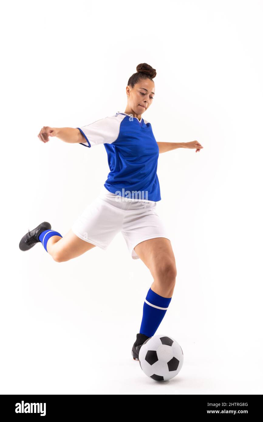 Die ganze Länge der Biracial junge Spielerin mit ausgestreckten Armen treten Ball während des Fußballs Stockfoto