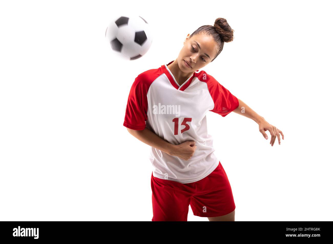 Biracial junge weibliche Fußballspielerin schlagen Fußball mit Schulter, während Fußball spielen Stockfoto
