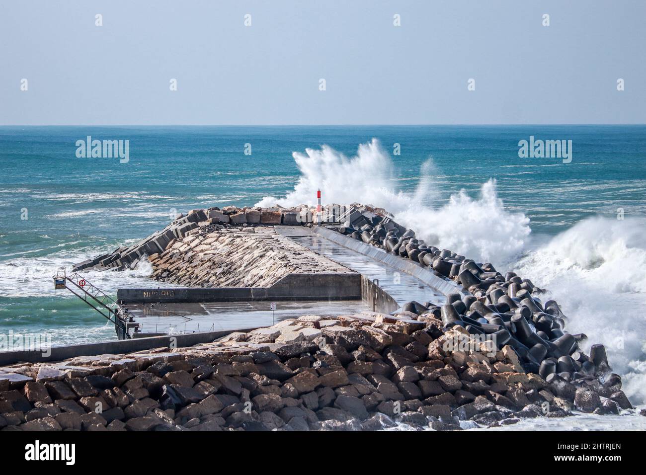 An einem stürmischen Tag traf von einem Pier aus eine große Meereswelle in einem Steg ein Stockfoto