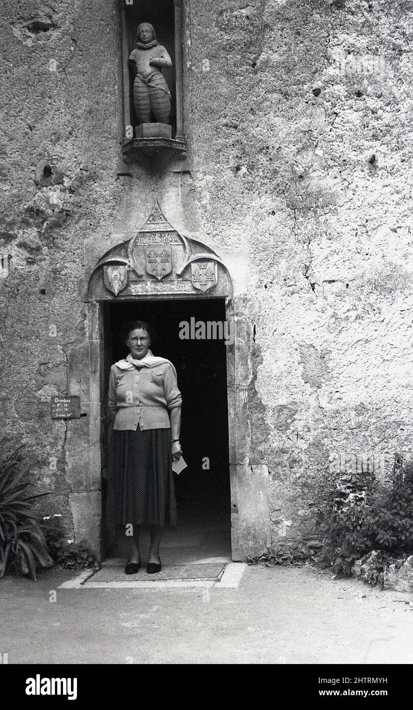 1950s, historisch, eine Besucherin, die am Eingang des Maison Natale De Jeanne d'Arc in Domremy-la-Pucelle, Frankreich, steht. In diesem zweistöckigen Bauernhaus aus Stein wurde Anfang des 15.. Jahrhunderts die französische Heldin Jeanne d’Arc geboren. Stockfoto