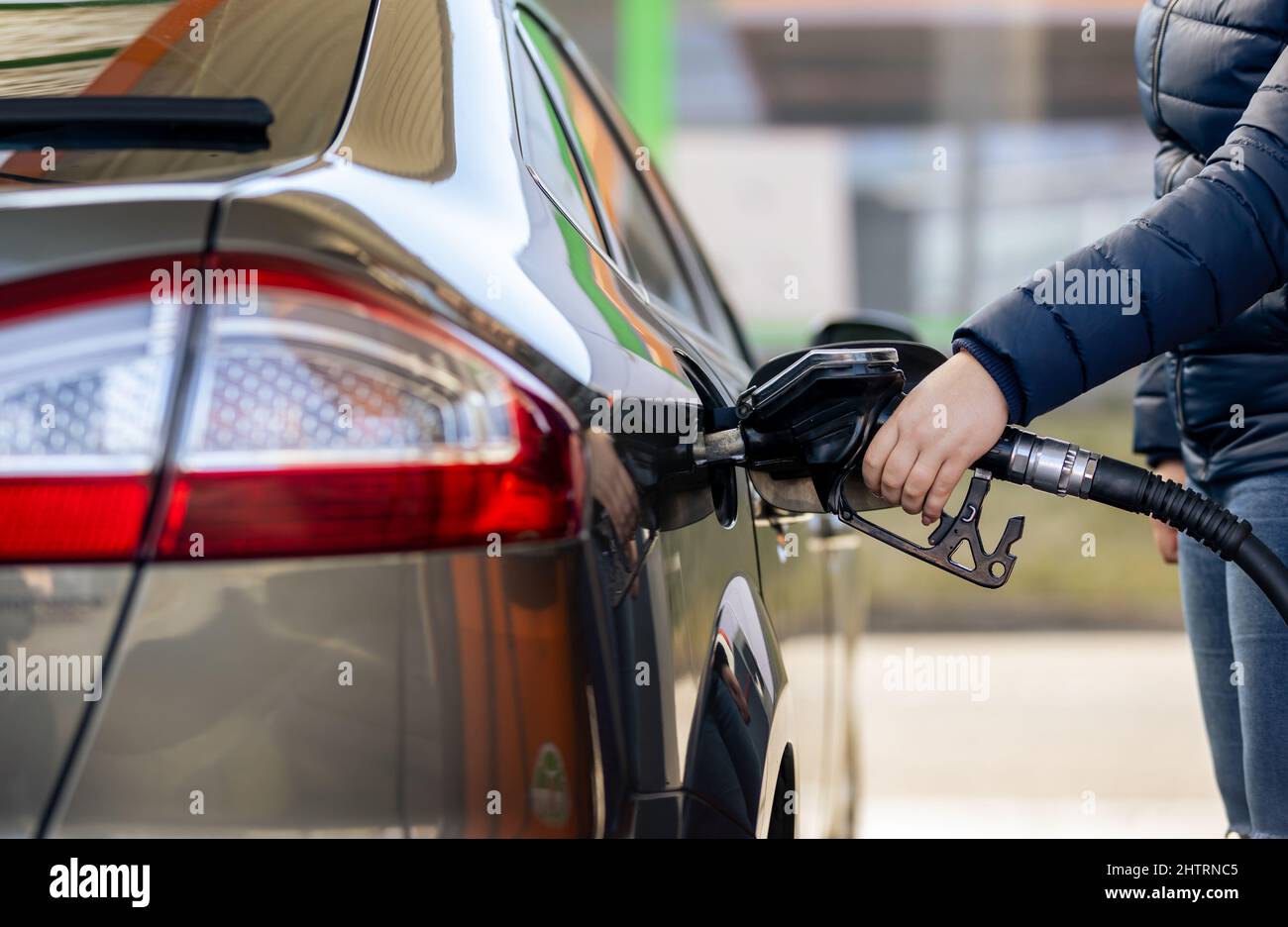 Prozess der Betankung eines Autos füllen mit Benzin an der Tankstelle, Pumpe Füllen Kraftstoffdüse im Kraftstofftank des Autos, hoher Preis für Benzin und Ölkraftstoff Stockfoto