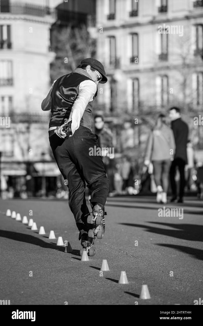 Paris, Frankreich - 27. Februar 2022 : Ein Pariser Rollschuh, der an einem sonnigen Tag in Schwarz-Weiß für die Touristen in Paris auftrat Stockfoto