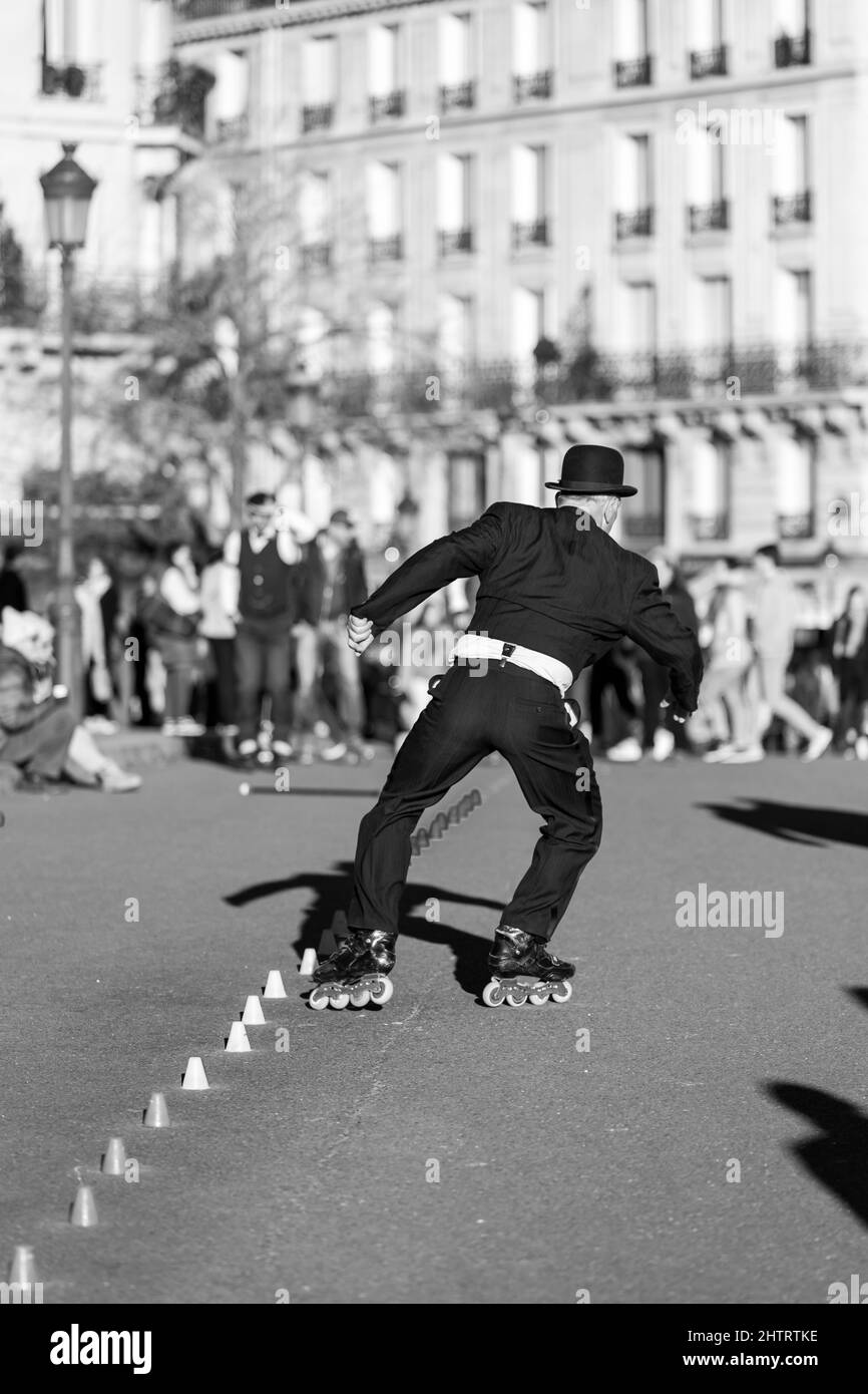 Paris, Frankreich - 27. Februar 2022 : Ein Pariser Rollschuh, der an einem sonnigen Tag in Schwarz-Weiß für die Touristen in Paris auftrat Stockfoto