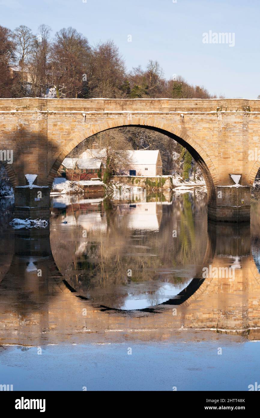 Die alte Maismühle, eingerahmt von einer vorbiegeten Brücke über den Fluss Wear, in Durham City, England, Großbritannien Stockfoto