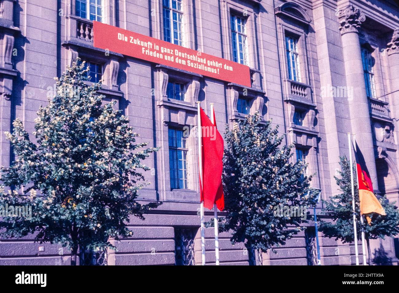Ost-Berlin, 1962. Der Slogan auf der Wand lautet: "Die Zukunft in ganz Deutschland gehört dem Frieden und dem Sozialismus." Stockfoto