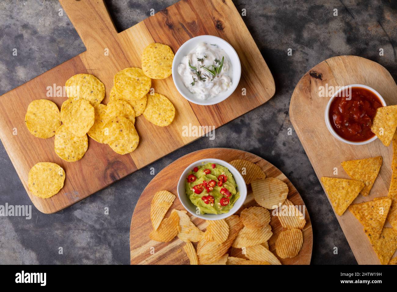 Direkt über Schuss von verschiedenen Chips mit verschiedenen Saucen serviert auf Servierbrett am Tisch Stockfoto