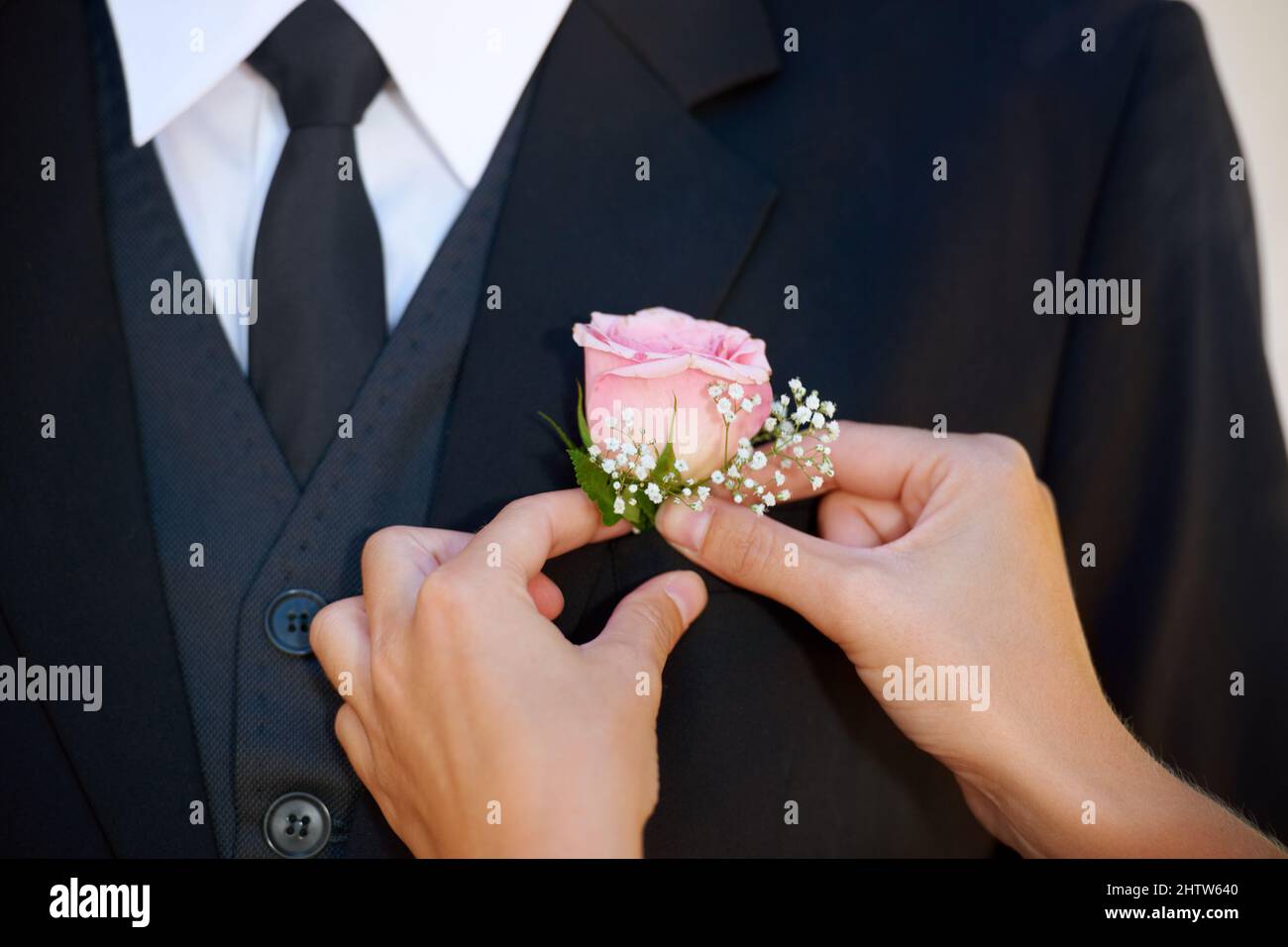 Der letzte Schliff. Zugeschnittenes Bild eines Bräutigams, der seine Boutonniere vor der Hochzeitszeremonie justiert. Stockfoto