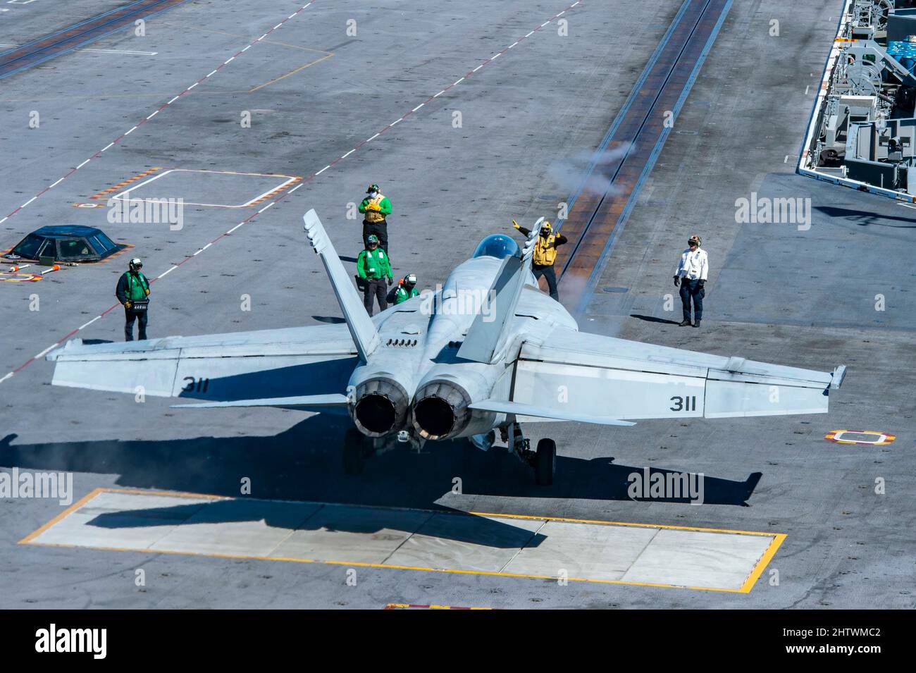220301-N-XK462-1093 PAZIFISCHER OZEAN (MÄRZ 1, 2022) eine F/A-18F Super Hornet aus den 'Fighting Redcocks' des Strike Fighter Squadron (VFA) 22 erhält Anweisungen von einem Seemann auf dem Flugdeck des Flugzeugträgers USS Nimitz (CVN 68). Nimitz führt derzeit Routineoperationen durch. (USA Navy Foto von Mass Communication Specialist Seaman Hannah Kantner Stockfoto