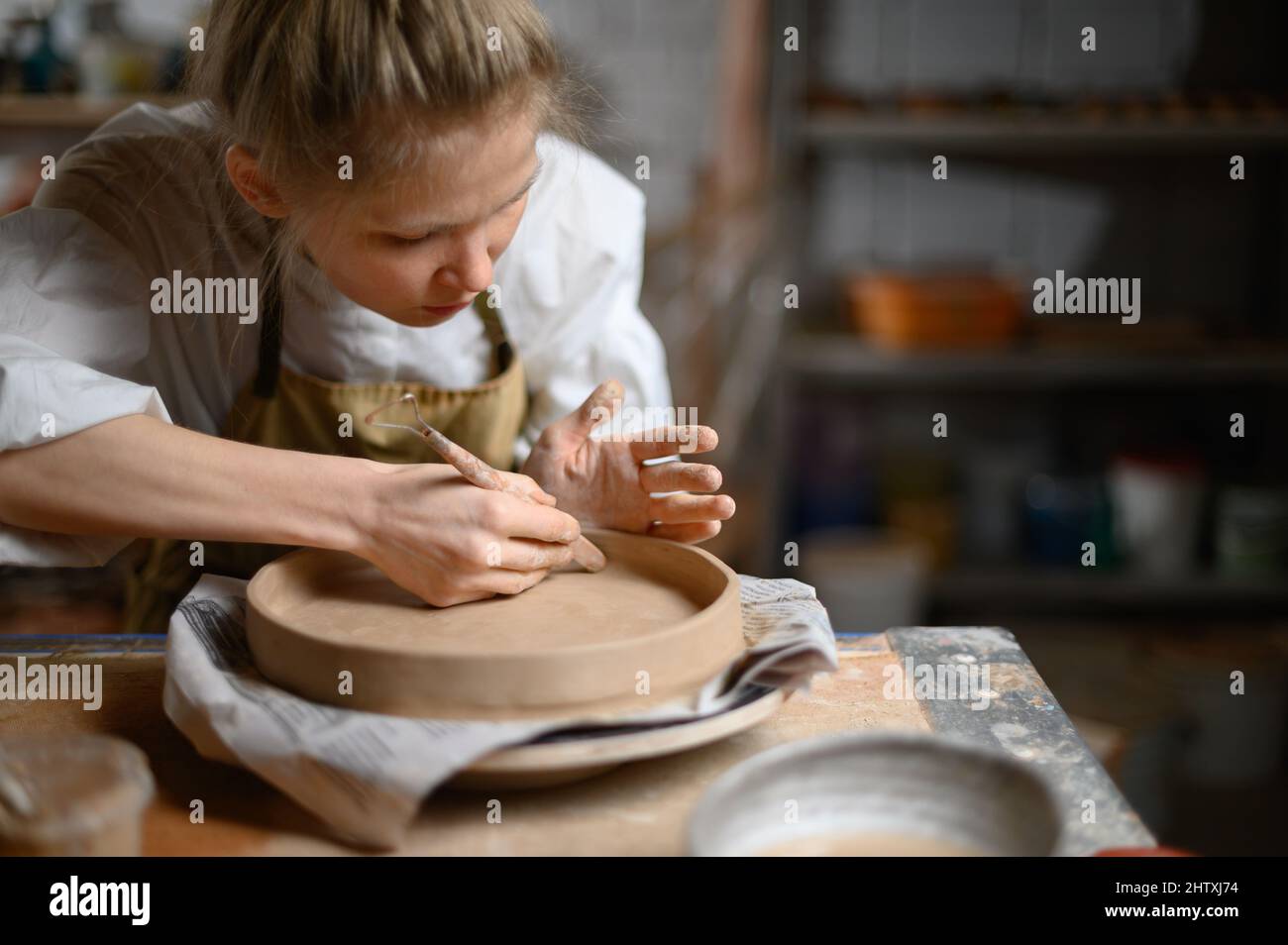 Mädchen machen Tonplatte in Keramik-Werkstatt Stockfoto
