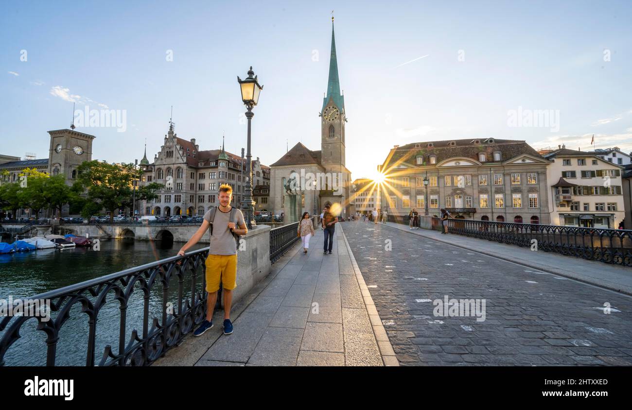 Tourist auf der Münsterbrücke über die Limmat, Fraumünster Kirche, Zürcher Altstadt, Sonnenstern bei Sonnenuntergang, Zürich, Kanton Zürich, Schweiz Stockfoto
