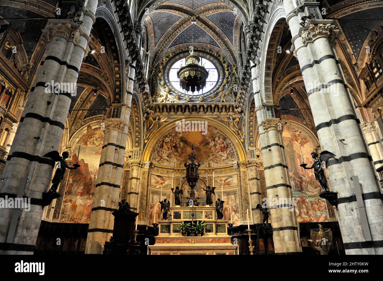 Altar und Apsis der Kathedrale Santa Maria Assunta von Siena, neben Säulen der romanisch-gotischen Architektur, Duomo di Siena, Siena Stockfoto