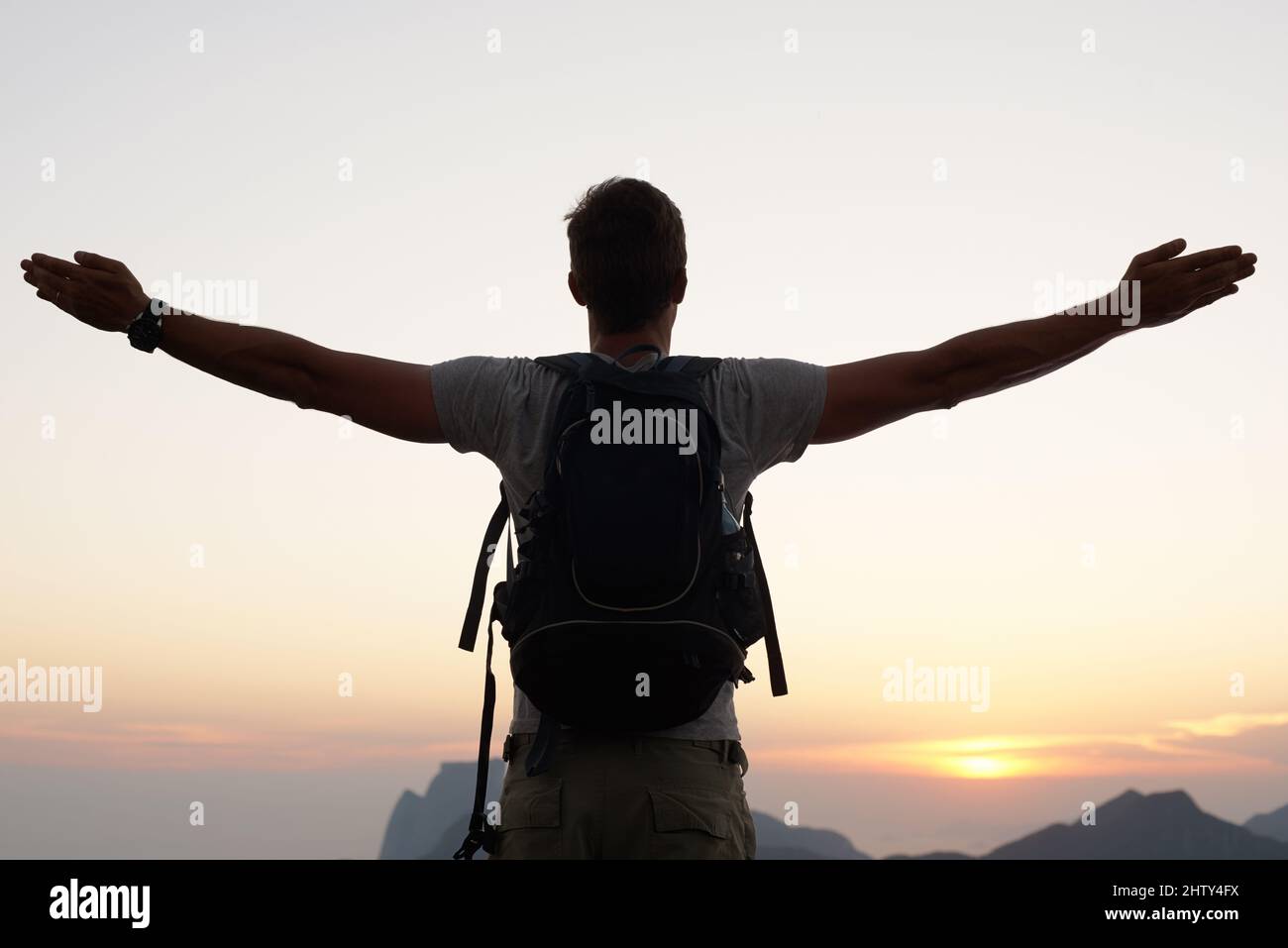 Seinen Platz in der Welt zu finden. Silhouette eines jungen Mannes, der gegen den Himmel steht. Stockfoto