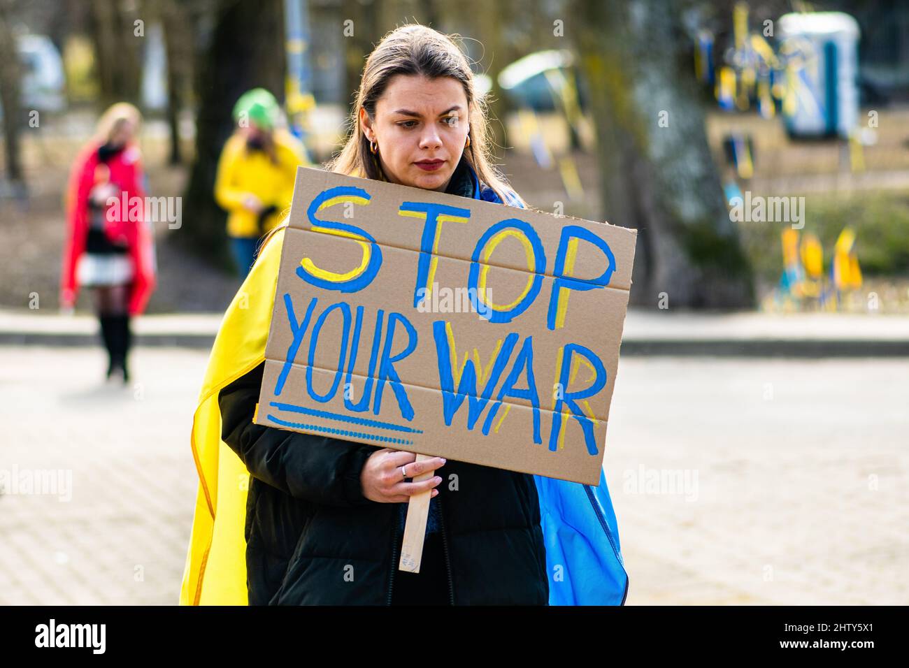 Schönes Mädchen während einer friedlichen Demonstration gegen den Krieg, Putin und Russland zur Unterstützung der Ukraine, mit Menschen, Plakate und Fahnen. Beenden Sie Den Krieg Stockfoto