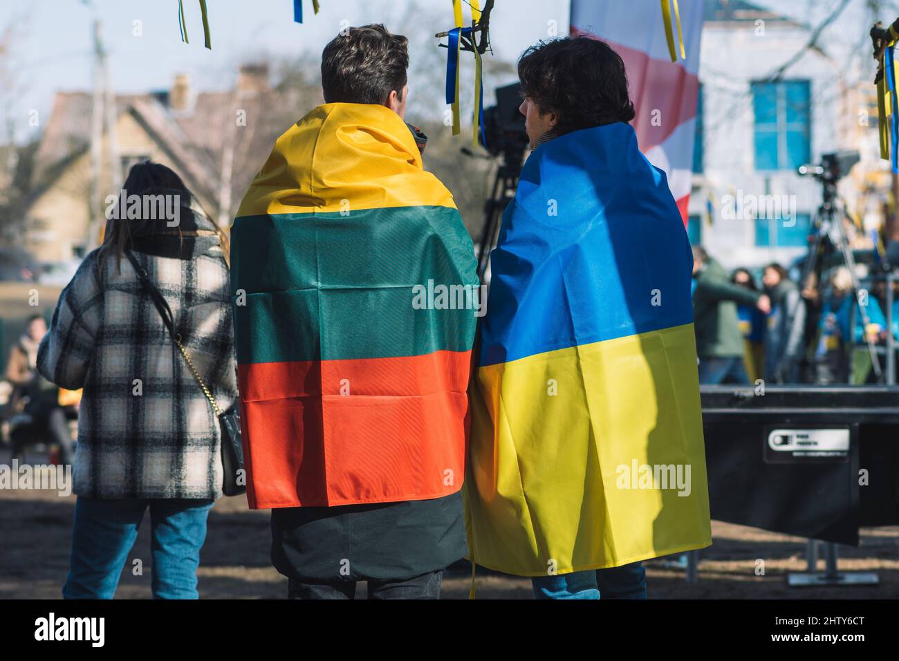 Ein paar Freunde während einer friedlichen Demonstration gegen den Krieg, Putin und Russland zur Unterstützung der Ukraine, mit ukrainischen und litauischen Fahnen Stockfoto