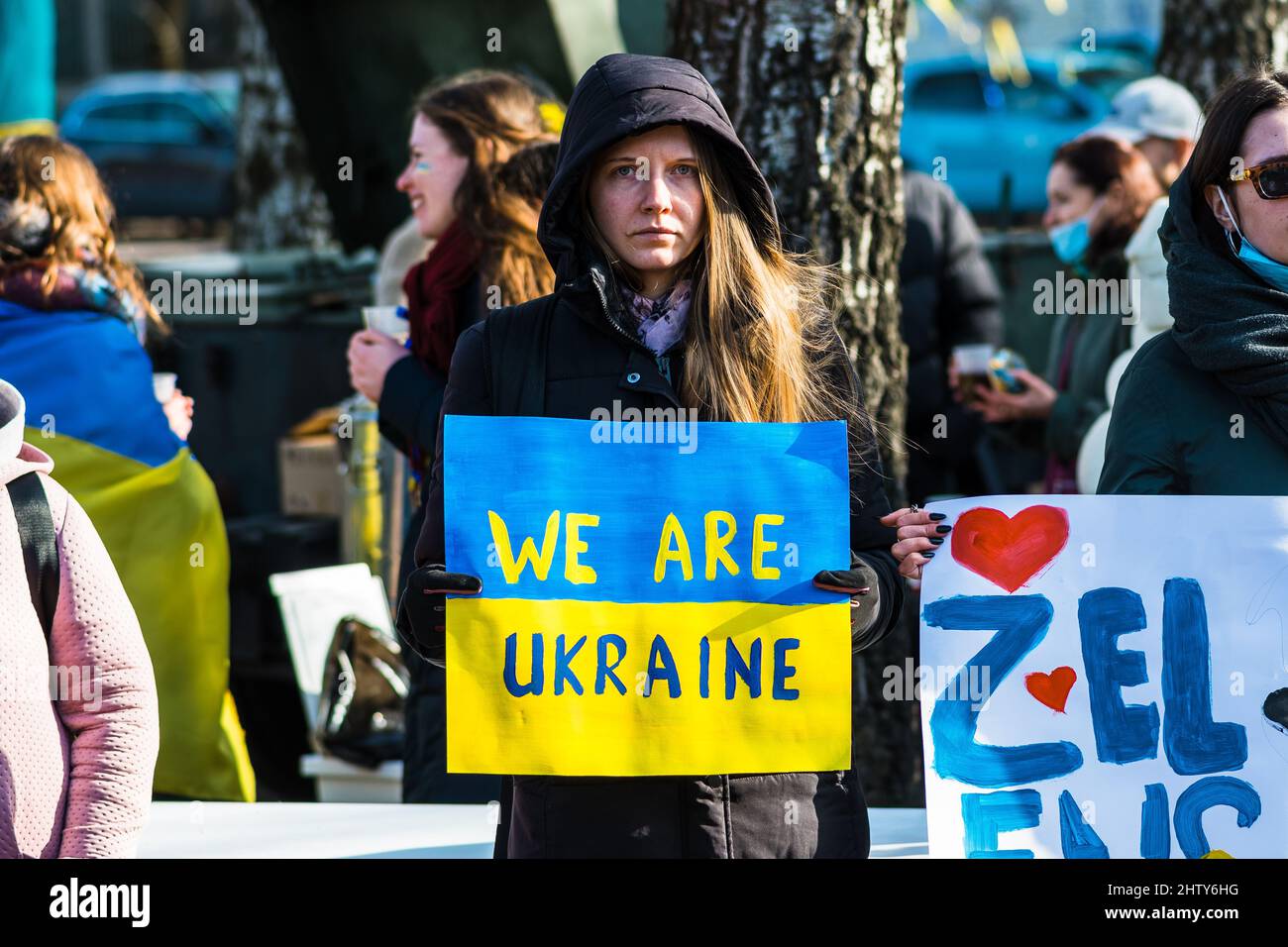 Schönes Mädchen während einer friedlichen Demonstration gegen den Krieg, Putin und Russland zur Unterstützung der Ukraine, mit Menschen, Plakate und Fahnen. Beenden Sie Den Krieg Stockfoto