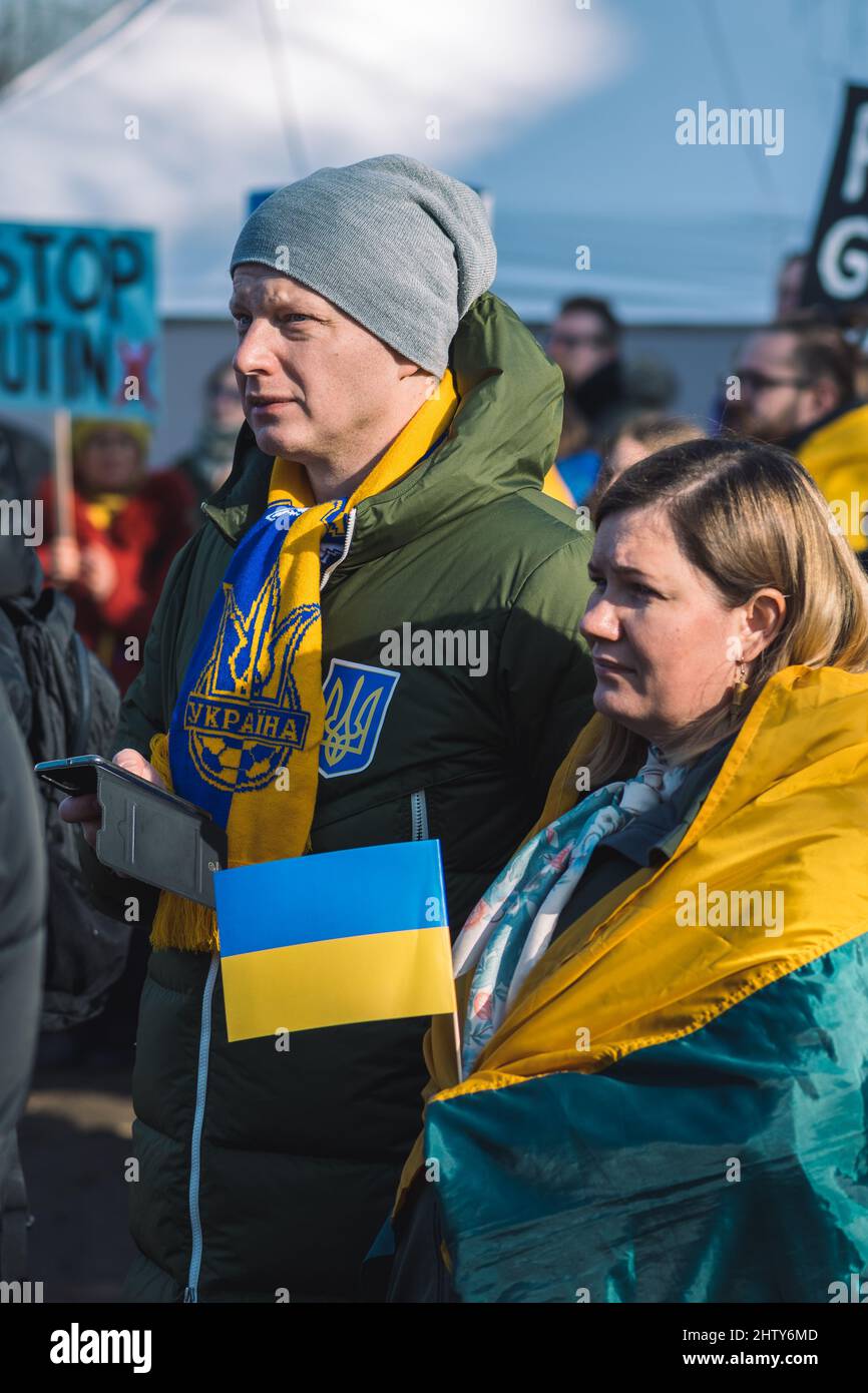 Paar während einer friedlichen Demonstration gegen den Krieg, Putin und Russland zur Unterstützung der Ukraine, mit Menschen, Plakaten und Fahnen. Beenden Sie Den Krieg Stockfoto