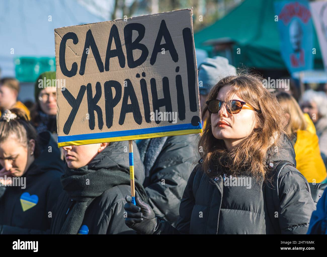 Schönes Mädchen während einer friedlichen Demonstration gegen den Krieg, Putin und Russland zur Unterstützung der Ukraine, mit Menschen, Plakate und Fahnen. Beenden Sie Den Krieg Stockfoto