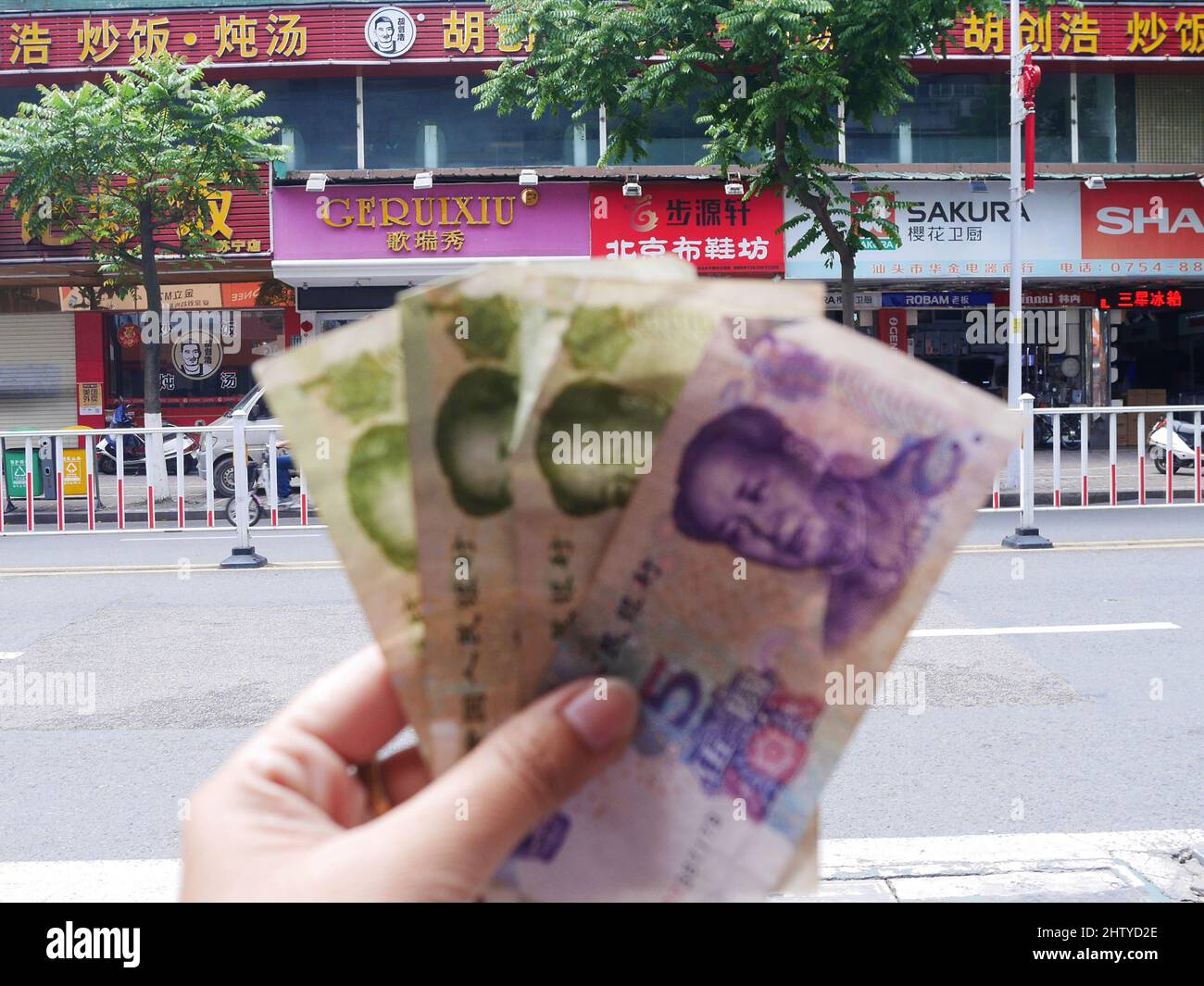Chinesen und ausländische Reisende besuchen und halten Geldscheine mit Yuan-Show und machen Fotos auf dem Straßenmarkt Altstadt in Shantou Altstadt oder Swato Stockfoto
