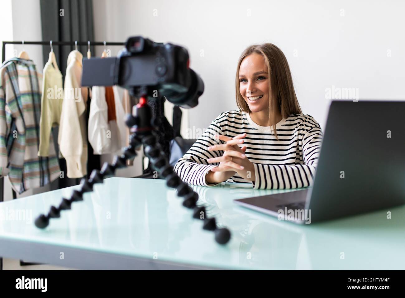 Selbstbewusste junge Vloggerin sitzt am Schreibtisch und dreht Live-Übertragungen mit professioneller Kamera, erfolgreiche Millennial-Girl-Sprecherin oder Coach sprechen reco Stockfoto