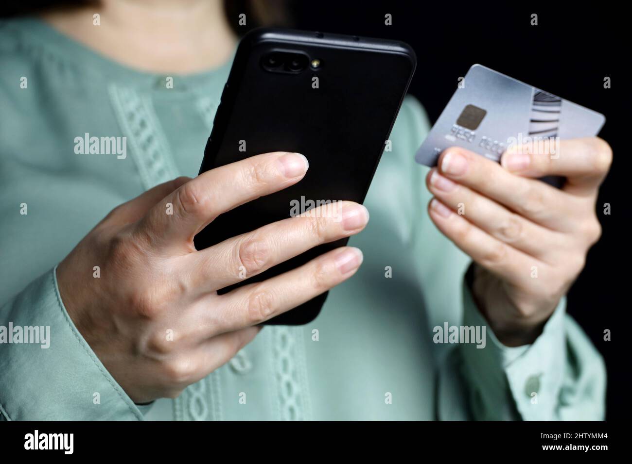 Frau, die Smartphone und Kreditkarte in den Händen hält. Konzept der Sperrung von Transaktionen und Online-Zahlungen Stockfoto