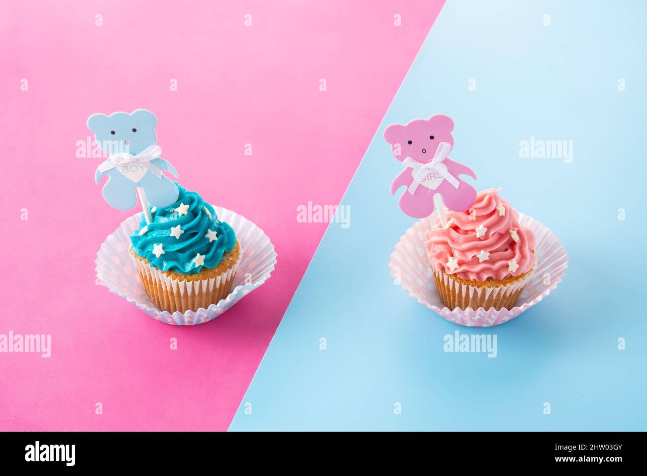 Rosa und blaue Cupcakes für die Babydusche auf rosa und blauem Hintergrund Stockfoto