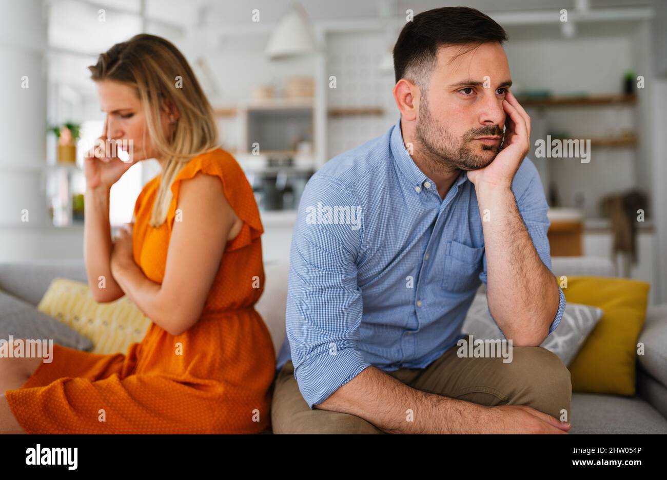 Traurige, nachdenkliche Paare, die an Beziehungsprobleme denken, die auf dem Sofa sitzen, Konflikte in der Ehe. Stockfoto