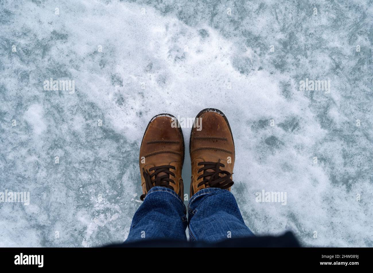 Draufsicht auf Stiefel auf gefrorener Meeresoberfläche. Stockfoto