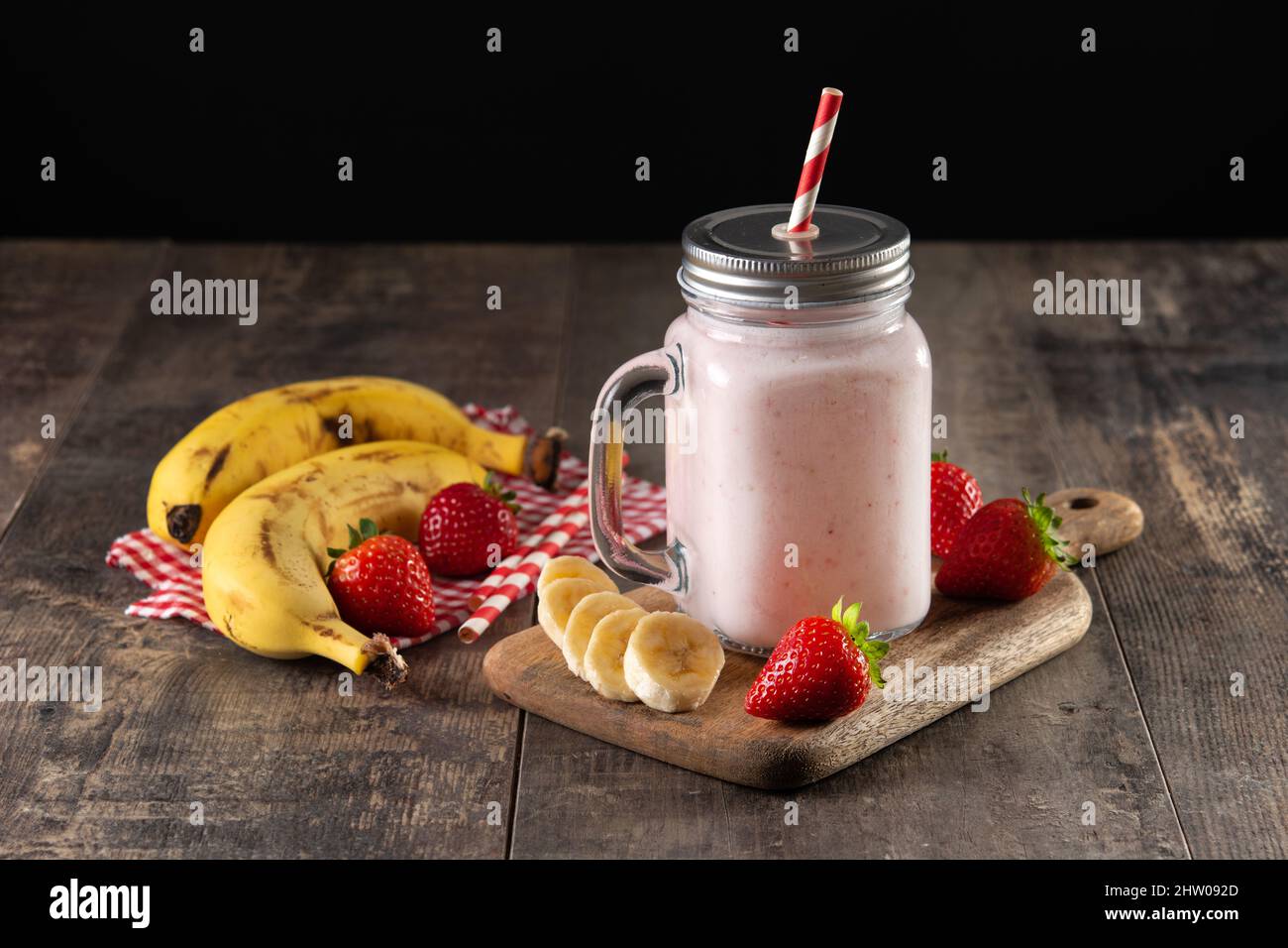Erdbeer- und Bananenmoothie im Glas auf Holztisch zubereiten Stockfoto