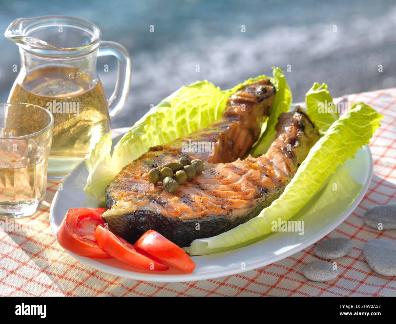 Gegrillter frischer Thunfisch, Kapern, Retsina und griechische Sonne, eine perfekte Kombination. Stockfoto