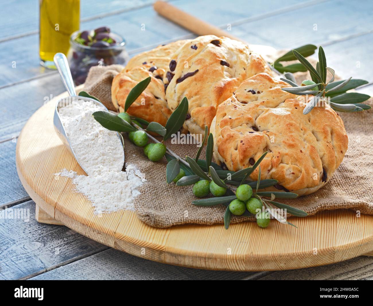 Köstliches hausgemachtes traditionelles Olivenbrot, serviert auf einem Holzgericht, hergestellt aus hochwertigen Zutaten, Bio-Produkten wie Oliven, Olivenöl, Mehl. Stockfoto