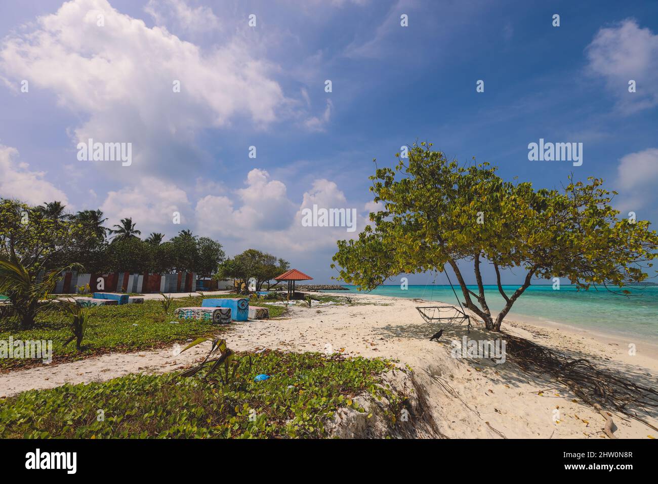 Leerer weißer Sandstrand mit Palmen und blauem Meerwasser auf der Paradise Maafushi Insel, Malediven Stockfoto