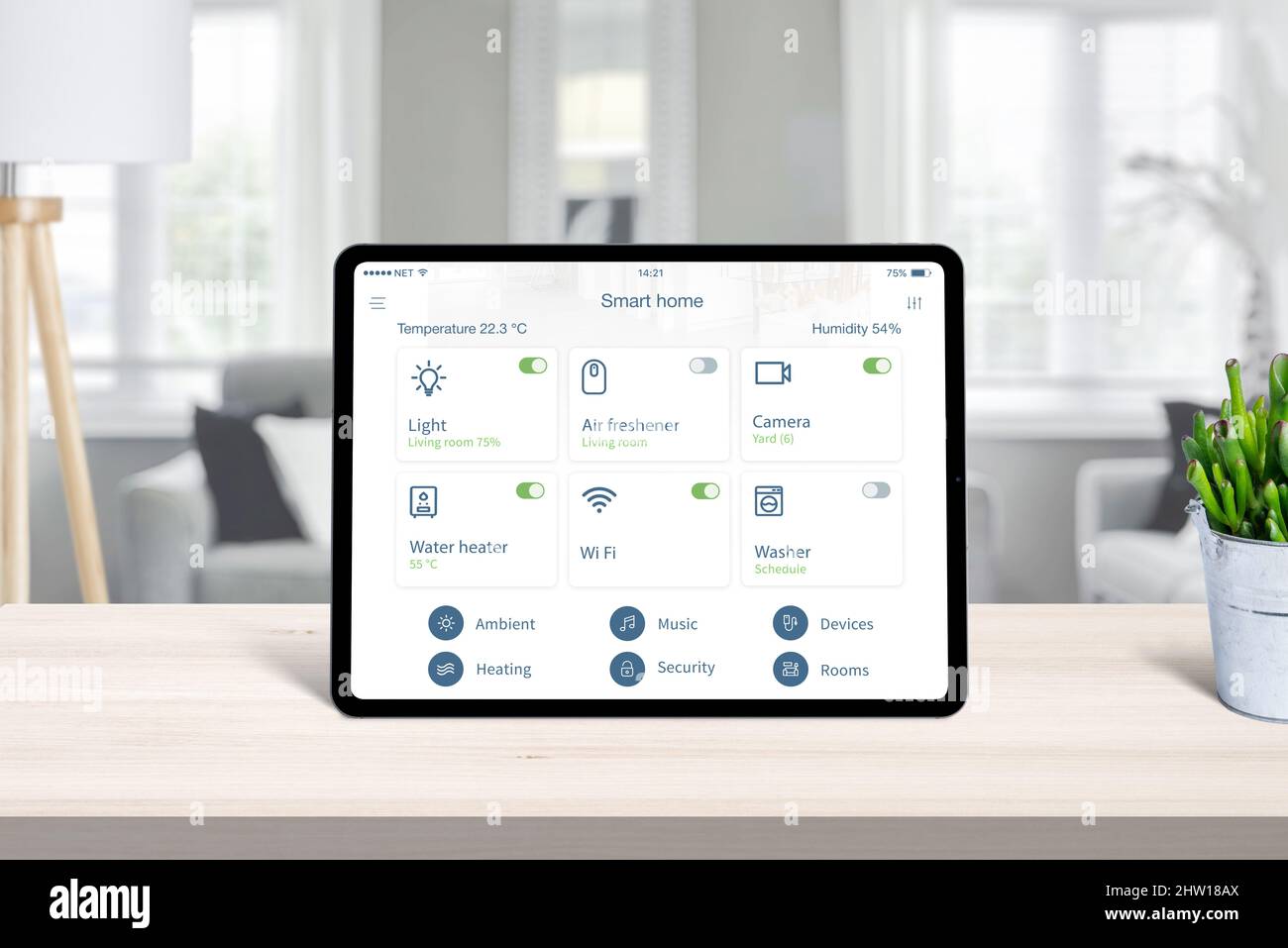 Tablet mit Smart-Home-App auf dem heimischen Schreibtisch. Konzept der Heimautomatisierung Conrol App mit häufig verwendeten Geräten Stockfoto