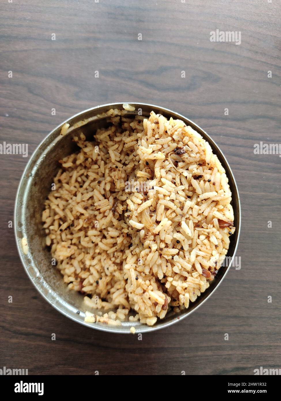 Puliyogare (Pulihora)-Lunchbox mit würzigem Geschmack. Mit Chinthapandu Pulihora, einem traditionellen südindischen Reisgericht mit Tamarinde. Stockfoto