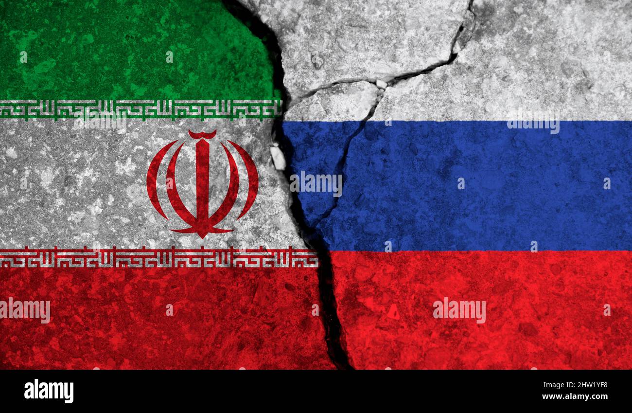 Politische Beziehung zwischen dem Iran und russland. Nationalflaggen auf rissem Betongrund Stockfoto