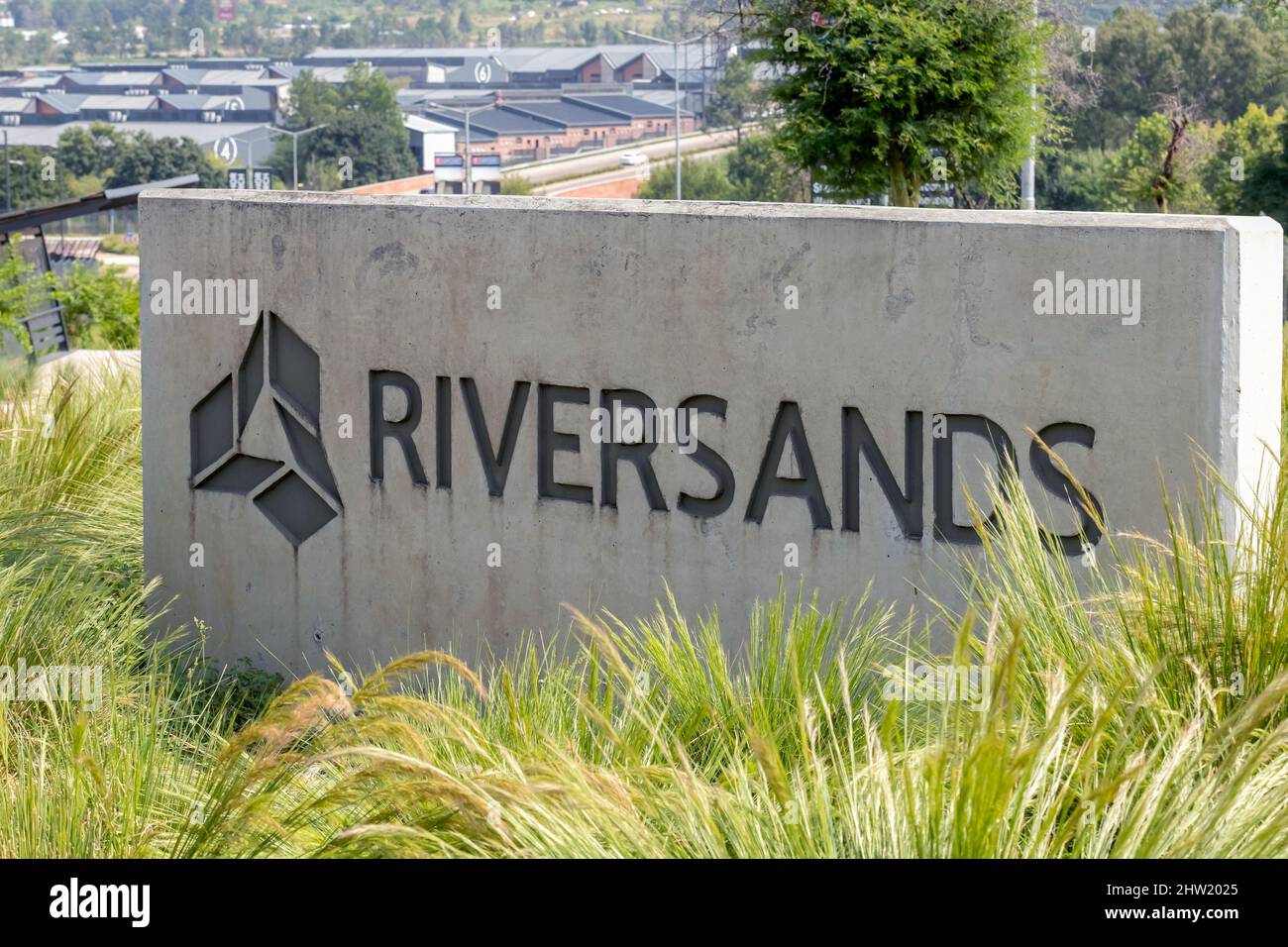 Johannesburg, Südafrika, 24.. Februar - 2022: Zement-Beschilderung der neuen großen industriellen Entwicklung mit Lagerhäusern im Hintergrund. Stockfoto