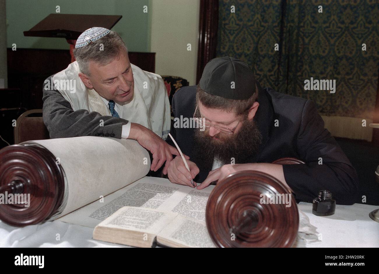 Der Oberrabbiner Jonathan Sacks war Ehrengast für die Aufnahme der letzten Briefe in eine neue Sefer-Torah in der Synagoge der hebräischen Kongregation Singers Hill am Sonntag, dem 15. März 1998. Mitglieder der Gemeinde sowie der Oberrabbiner fügten jeweils einen einzigen Brief hinzu. Stockfoto