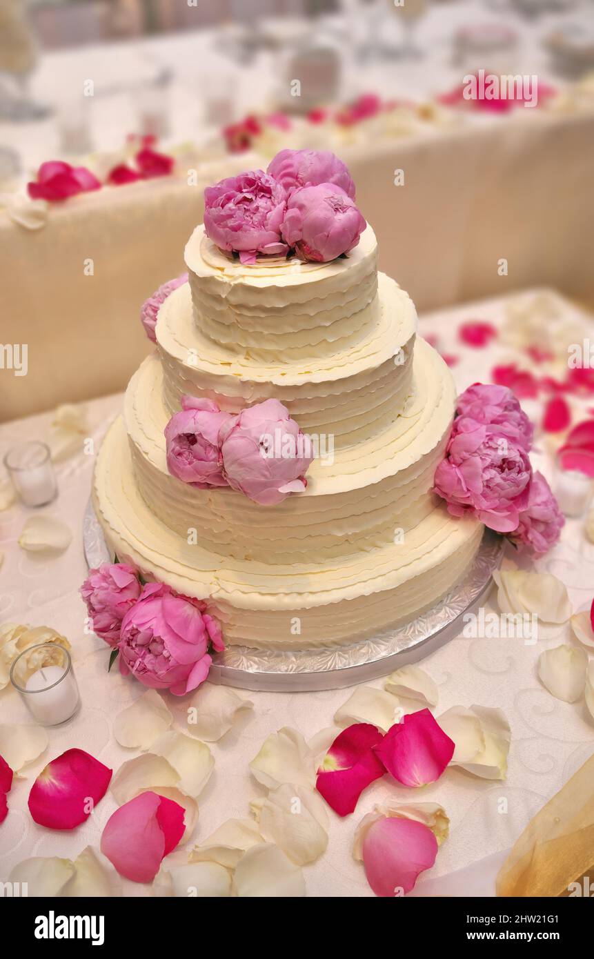 Eine elegante, mit Pfingstrosen verzierte Hochzeitstorte mit Schmetterlingsdesign Stockfoto