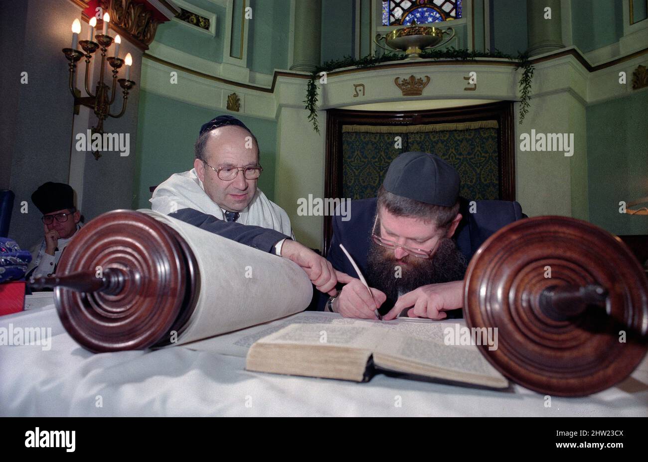 Der Oberrabbiner Jonathan Sacks war Ehrengast für die Aufnahme der letzten Briefe in eine neue Sefer-Torah in der Synagoge der hebräischen Kongregation Singers Hill am Sonntag, dem 15. März 1998. Mitglieder der Gemeinde sowie der Oberrabbiner fügten jeweils einen einzigen Brief hinzu. Rev Uzi Brown ist der Schreiber. Stockfoto