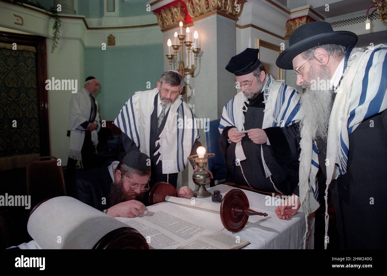 Der Oberrabbiner Jonathan Sacks war Ehrengast für die Aufnahme der letzten Briefe in eine neue Sefer-Torah in der Synagoge der hebräischen Kongregation Singers Hill am Sonntag, dem 15. März 1998. Mitglieder der Gemeinde sowie der Oberrabbiner fügten jeweils einen einzigen Brief hinzu. Rev Uzi Brown ist der Schreiber. Stockfoto