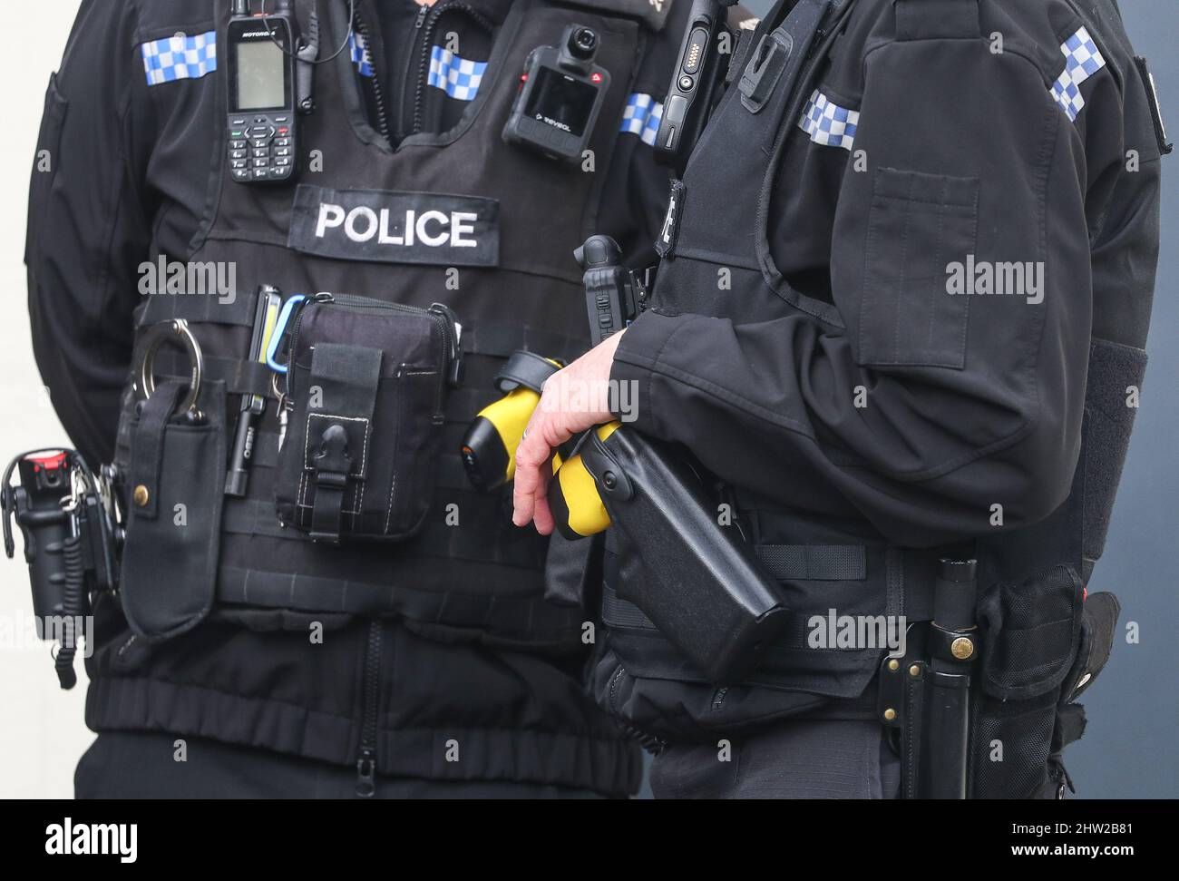 Britischer Polizist mit taktischer Weste, Tazer-Pistole und Body-Kamera. Stockfoto