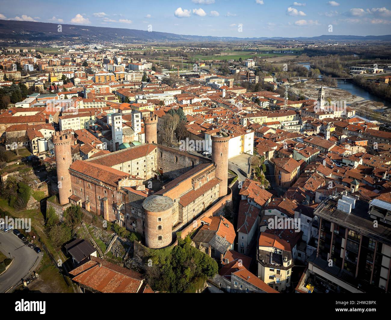 Luftaufnahme des historischen Zentrums mit dem Schloss mit seinen roten Türmen im Vordergrund. Ivrea, Italien - März 2021 Stockfoto