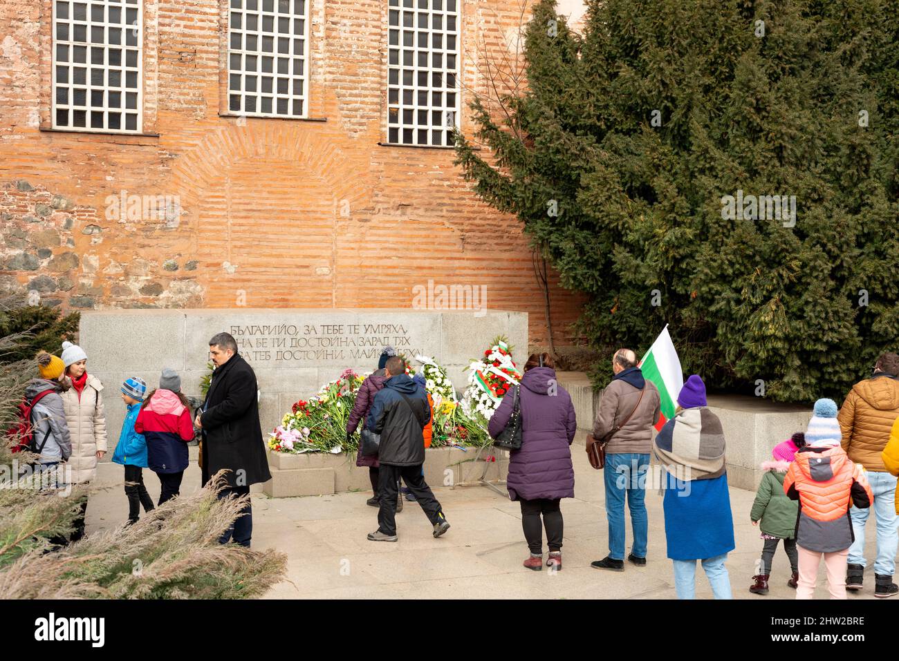 Sofia, Bulgarien. 03. März 2022. Menschen, die vor der Sophienkirche Schlange stehen, um Blumen an das Denkmal des unbekannten Kriegers zu legen, in Bezug auf die Erinnerung an die bulgarischen Soldaten, die ihr Leben in Kriegen verloren haben, während die Bulgaren den Bulgarischen Nationalfeiertag feiern. Stockfoto