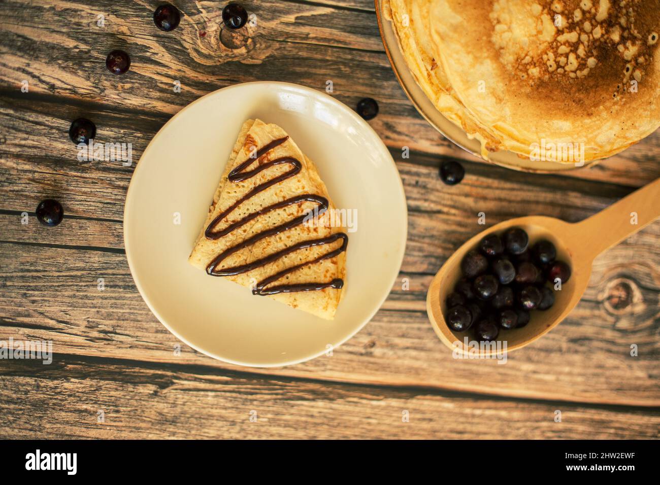 Leckere Pfannkuchen mit Schokoladensauce frische Heidelbeeren auf einem rustikalen Holztisch. Rustikaler brauner Tisch. Stockfoto