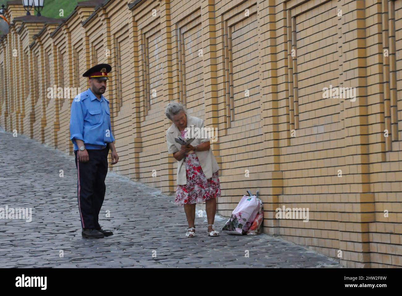 Der Sicherheitsmann im Kiewer Höhlenkloster hält an, um mit einem Gemeindemitglied in der ukrainischen Hauptstadt Kiew zu plaudern. Stockfoto