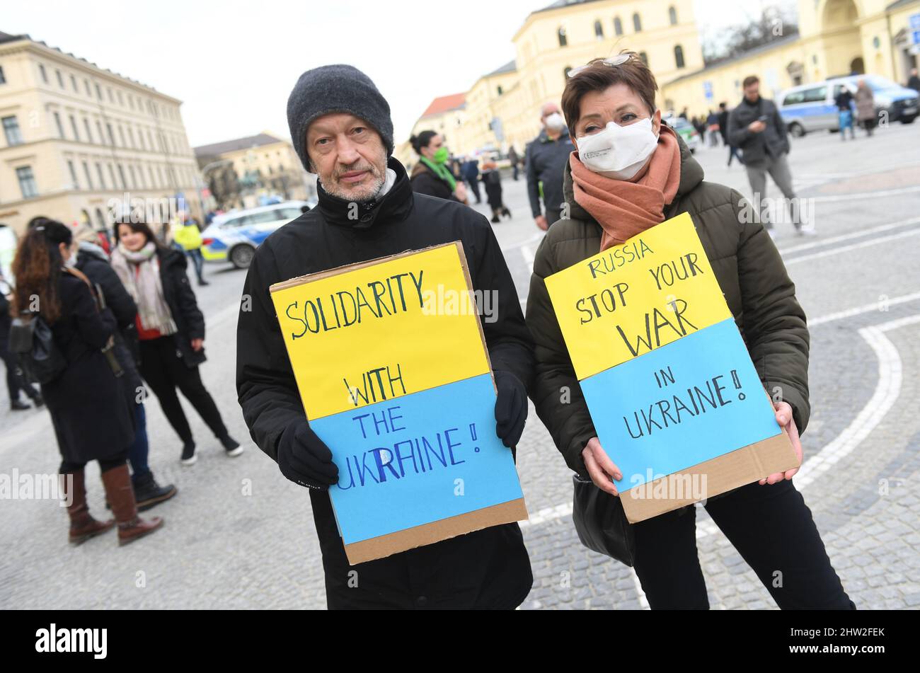 München, Deutschland. 03. März 2022. Demonstranten, die Plakate mit den Aufschrift „Solidarität mit der Ukraine“ und „Stoppt den Krieg in der Ukraine“ halten, stehen auf dem Odeonsplatz in der Landeshauptstadt während eines weltweiten Protests am Freitag für die Zukunft gegen den Krieg in der Ukraine. Quelle: Felix Hörhager/dpa/Alamy Live News Stockfoto