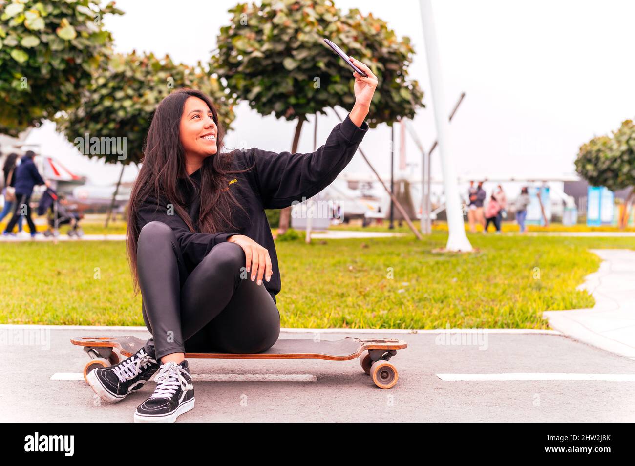 Schöne Skater Mädchen nimmt ein Selfie im Park Stockfoto